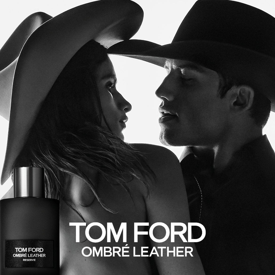 Descoperiți parfumul Tom Ford Ombré Leather, prezentat într-o sticlă neagră mată cu un capac argintiu, alături de un cuplu romantic purtând pălării de cowboy, într-o imagine alb-negru.