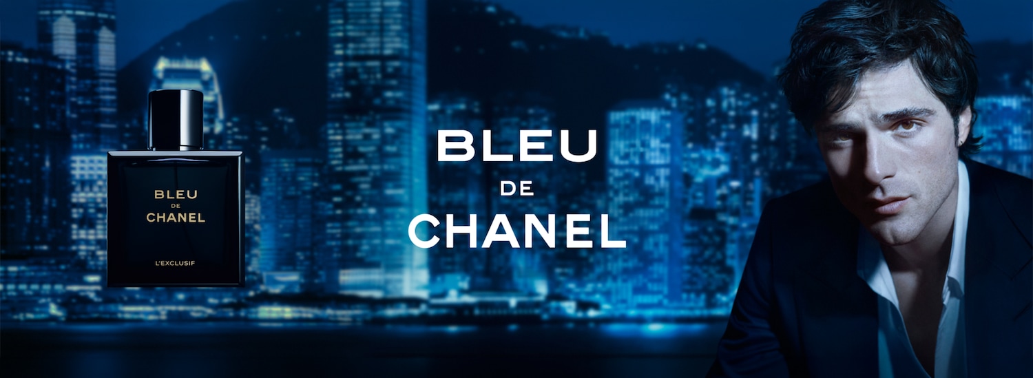 Un bărbat pe un fundal albastru care prezintă parfumul Bleu de Chanel.