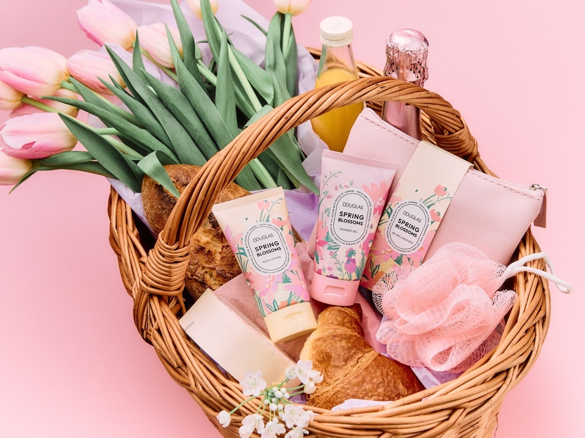 Coș din nuiele plin cu lalele roz, produse de patiserie și produse de beauty Douglas Spring Blossoms în ambalaje pastelate, perfecte pentru un răsfăț de Paște.