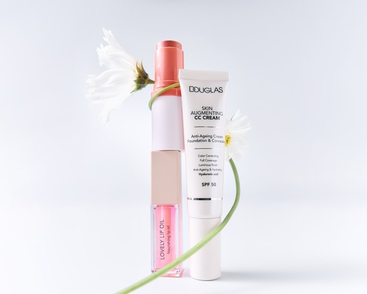 Douglas Skin Augmenting CC Cream cu SPF 50 este prezentată alături de Lovely Lip Oil, oferind beneficii anti-aging și de corectare a culorii.