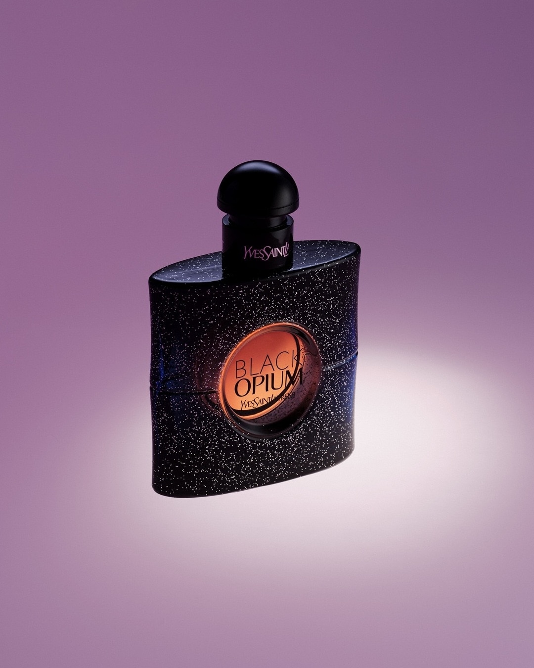 Black Opium de la Yves Saint Laurent, într-o sticlă neagră sclipitoare cu etichetă bronz, un parfum la fel de captivant ca o noapte înstelată.