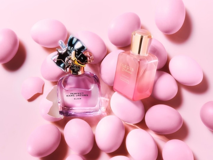 Două sticle de parfum, una de la Marc Jacobs și cealaltă de la Jardin Bohème, sunt înconjurate de ouă de Paște roz.